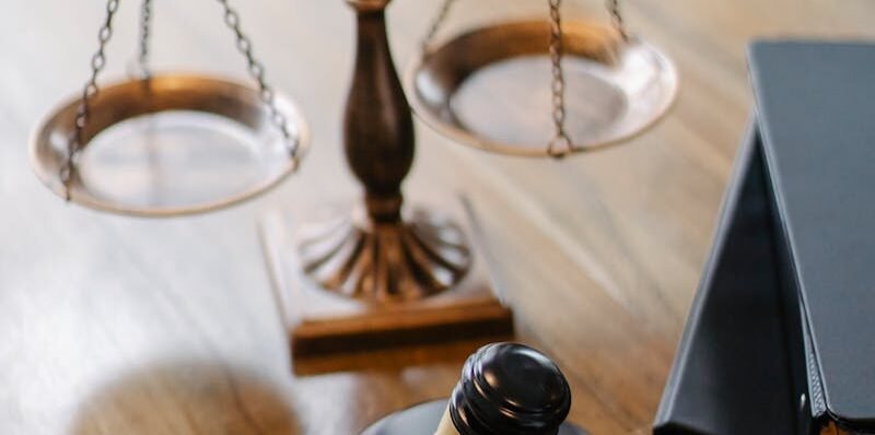 A striking image featuring a brass justice scale and gavel on a wooden desk, symbolizing law and justice.