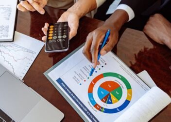 Two business professionals discussing financial documents and strategies at an office desk.