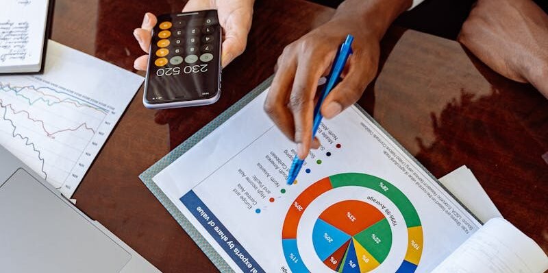 Two business professionals discussing financial documents and strategies at an office desk.