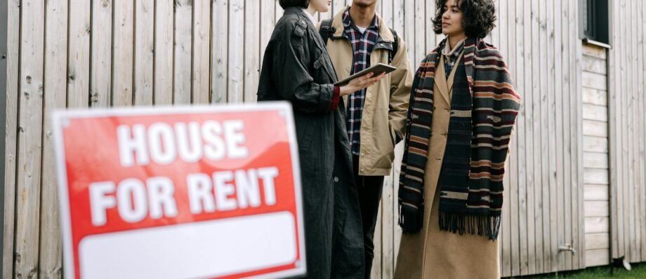 An interracial couple meets with a real estate agent to inquire about a house for rent.