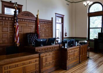 Interior view of an American courthouse in Kirksville, Missouri, featuring a judge's desk and flags.