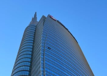 High-rise modern building in Milan under a clear blue sky, showcasing urban architecture.