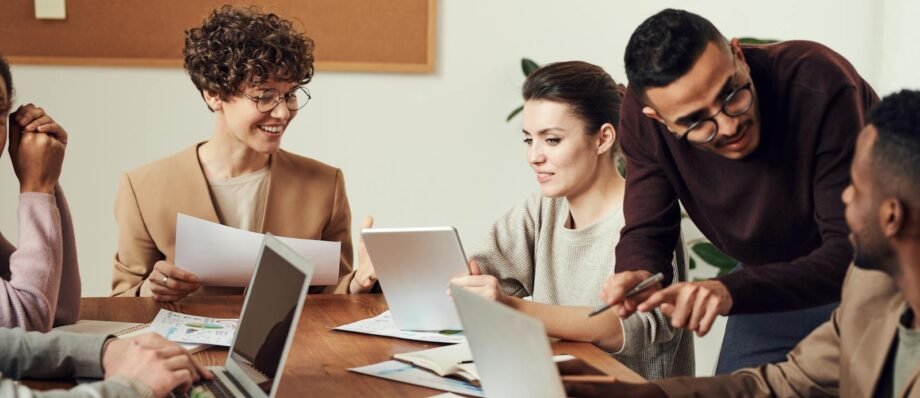 A diverse group of professionals engaged in a collaborative office meeting, sharing ideas and discussing projects.