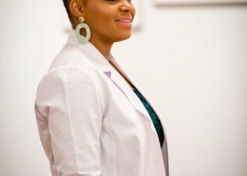 Portrait of a smiling female doctor in a white coat, exuding professionalism and confidence.