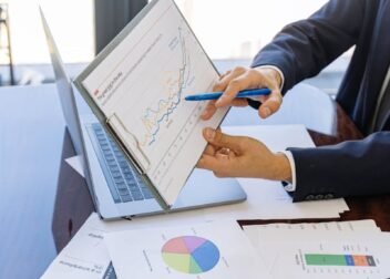 Business professionals discussing financial graphs and charts in an office setting.
