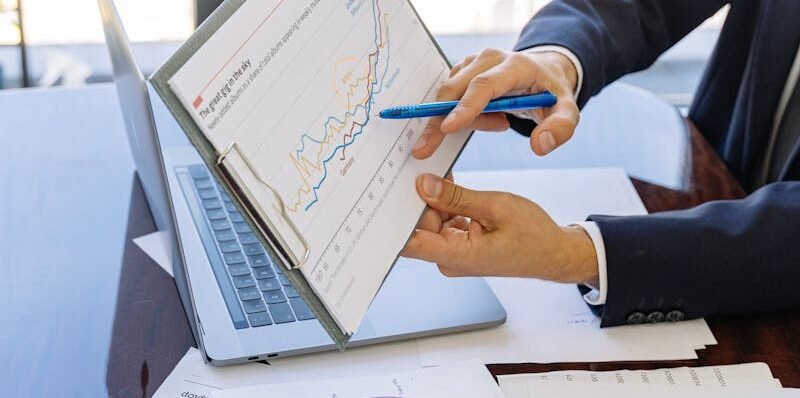 Business professionals discussing financial graphs and charts in an office setting.