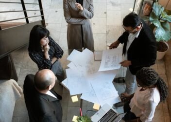 A team of professionals engage in a business meeting in a sleek, modern office setting.