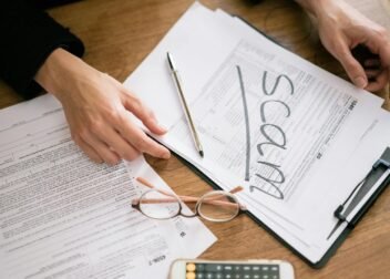 A close look at tax forms marked with scam, highlighting financial fraud risks.