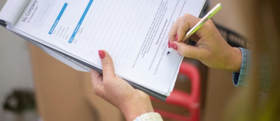 Close-up of woman's hand signing a document on a clipboard. Ideal for business and legal themes.
