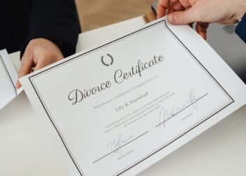 Overhead view of hands exchanging a divorce certificate in a professional environment.