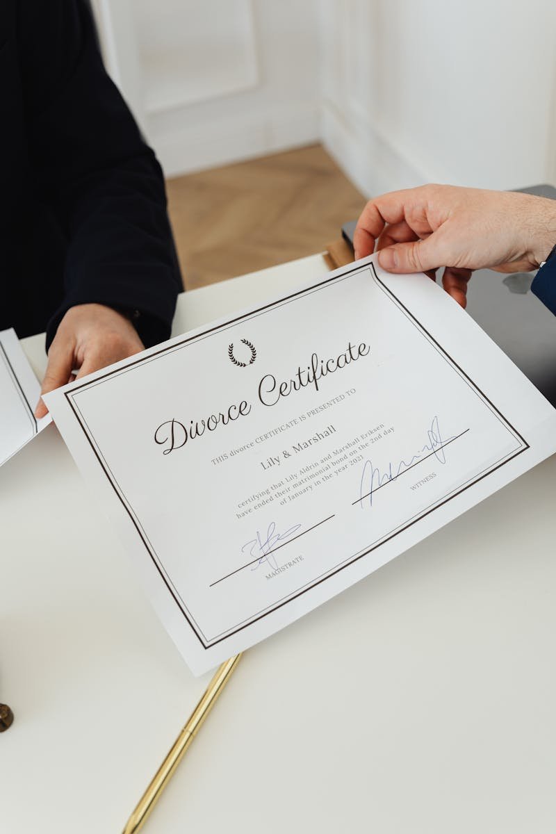 Overhead view of hands exchanging a divorce certificate in a professional environment.