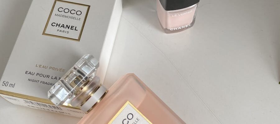 Elegant product shot of Chanel Coco Mademoiselle perfume and nail polish on a white surface.