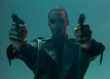 Conceptual cyberpunk image featuring an individual in a leather coat holding guns, evoking a futuristic theme.